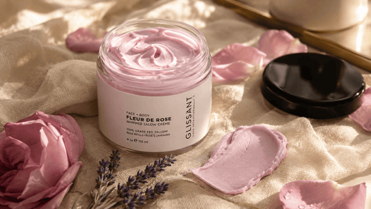 Open jar of Glissant Fleur de Rose whipped tallow crème with visible pink whipped texture, rose petals and lavender on natural linen in soft daylight