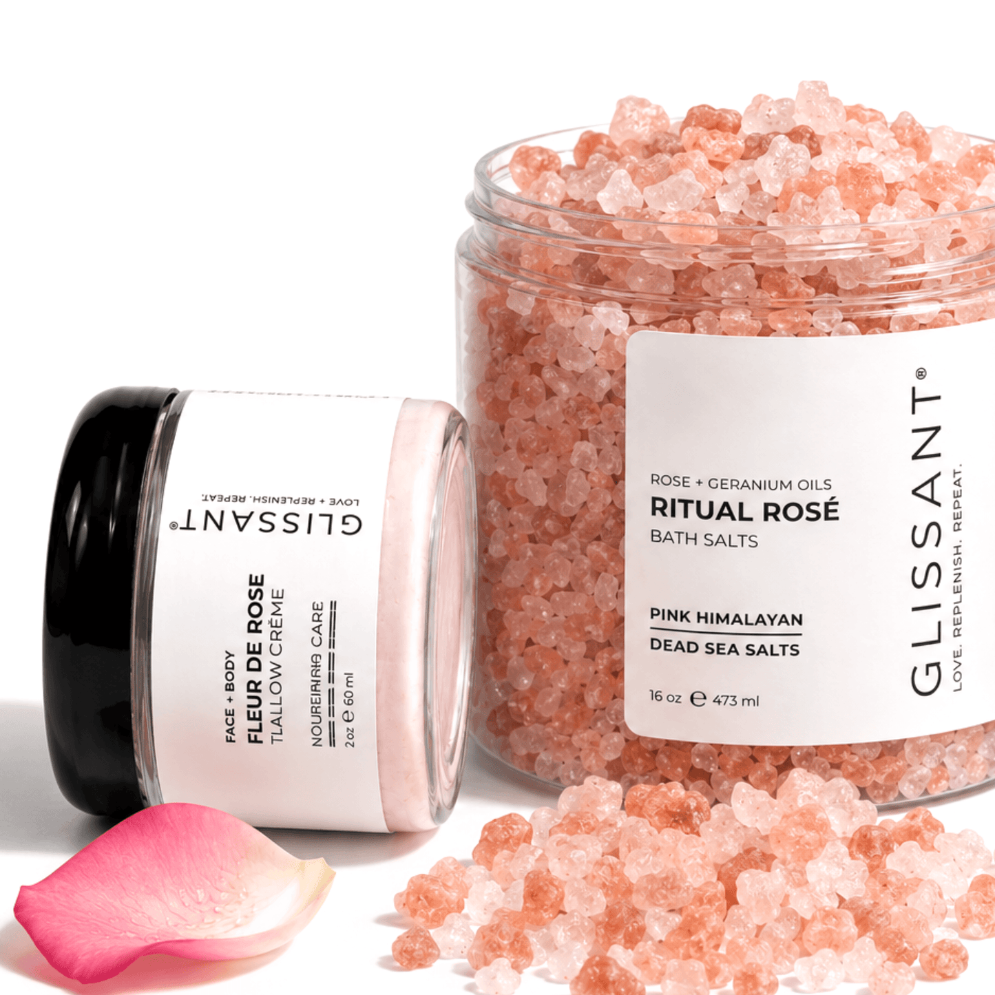 GLISSANT skincare set featuring a jar of Pink Himalayan Dead Sea Salts and a tube of Face & Mask Tallow Crème, with a pink rose petal on a clean white background.